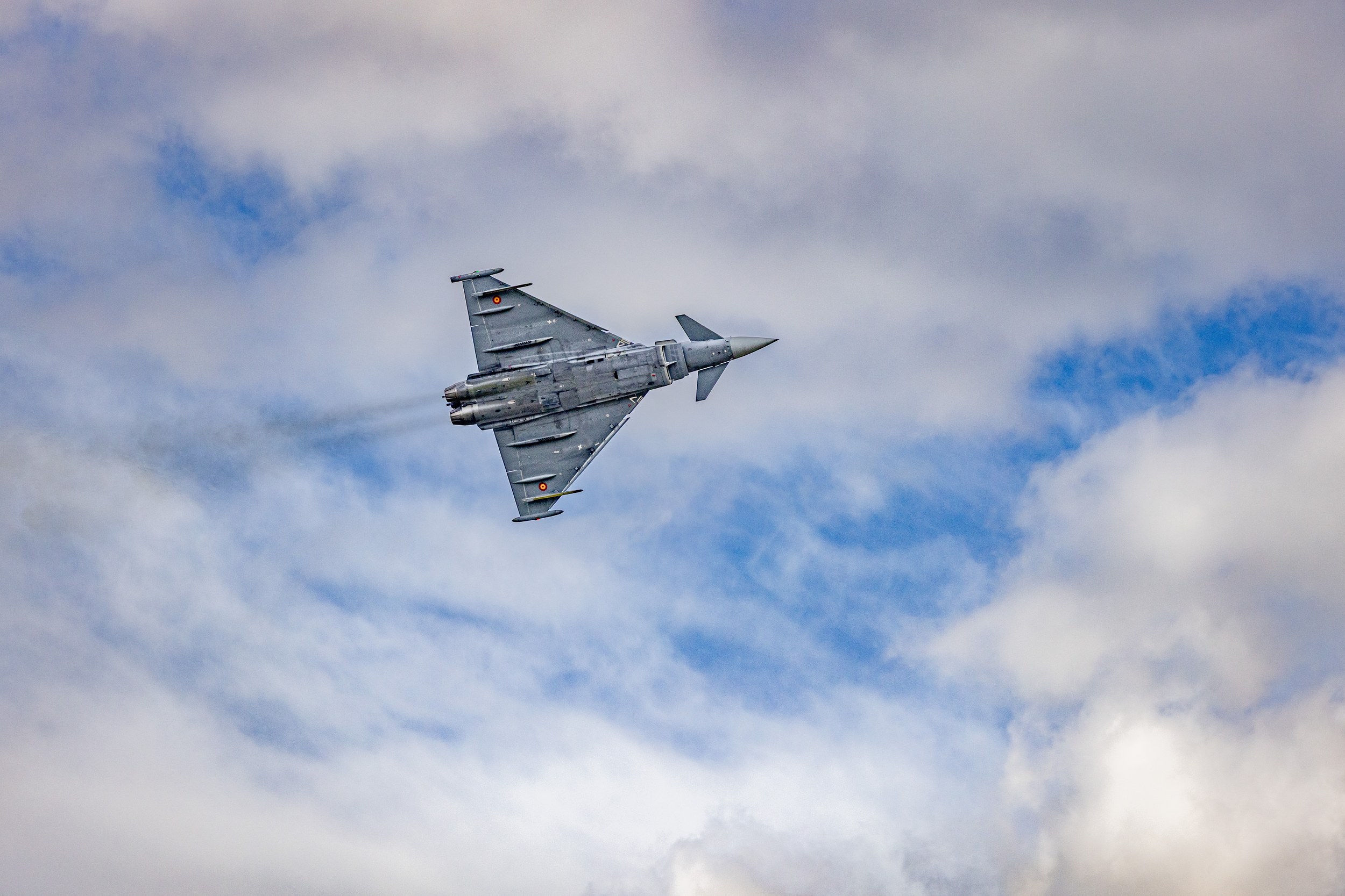 A Eurofighter Typhoon crosses the frame from left to right in a pronounced bank during the Flying Display.