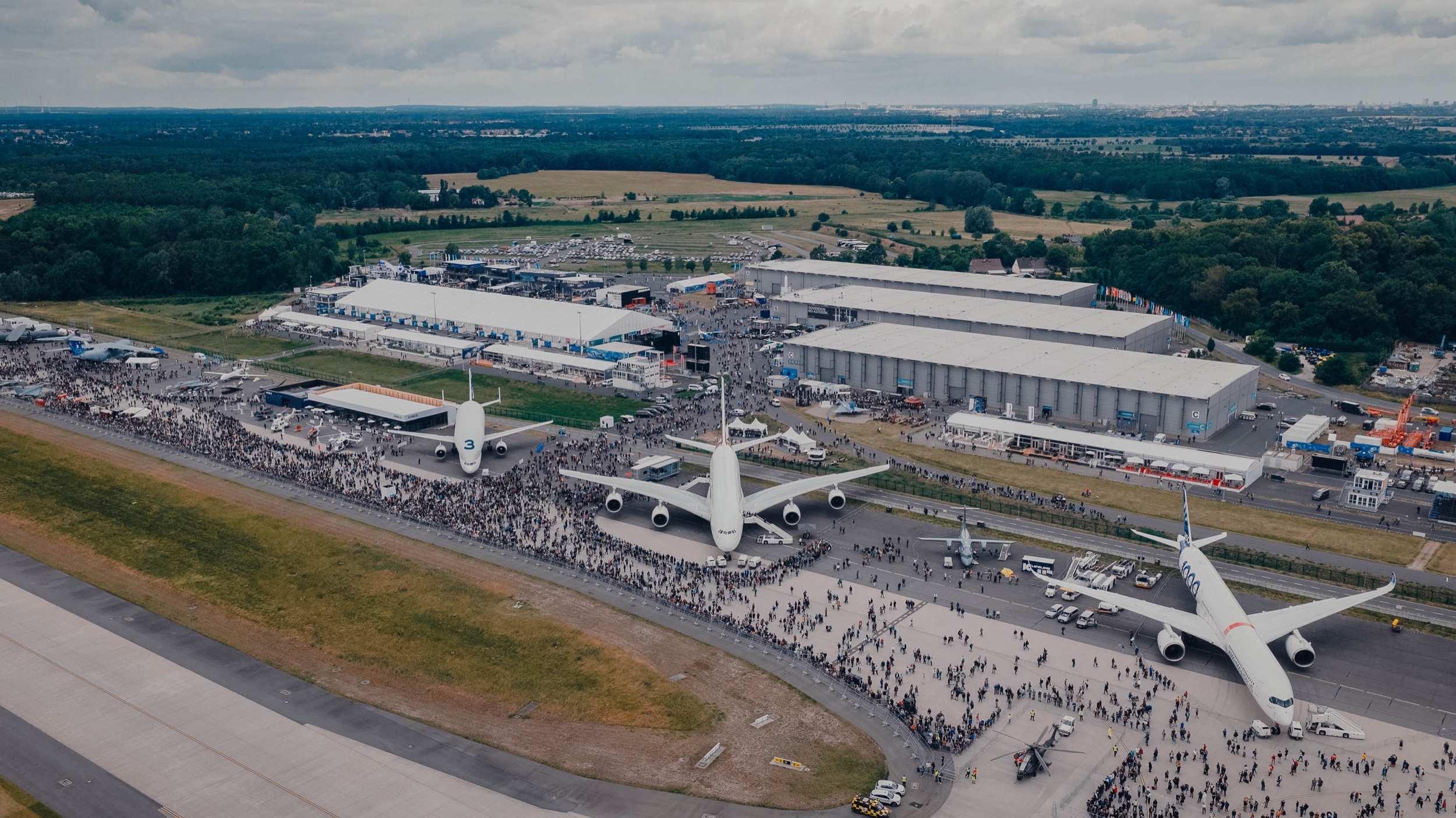 Luftaufnahme der ILA Berlin 2026 mit Messehallen, Großflugzeugen und Besucherströmen