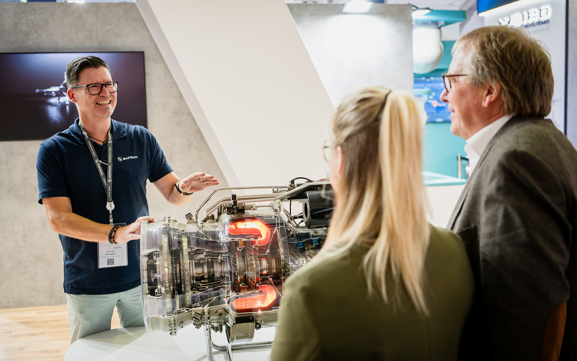 Safran staff member explains a transparent engine model to visitors