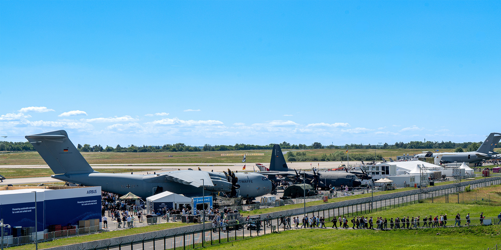 Panoramic view of the ILA exhibition grounds with visitors and aircraft