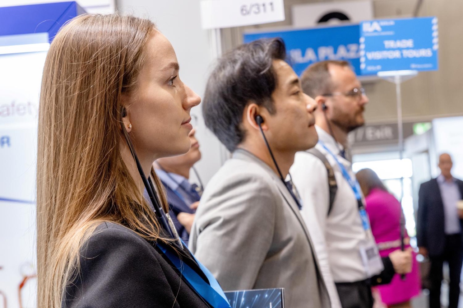 Trade visitors listening attentively with headphones